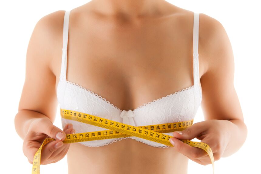 A girl measures her breasts, wanting to increase their size